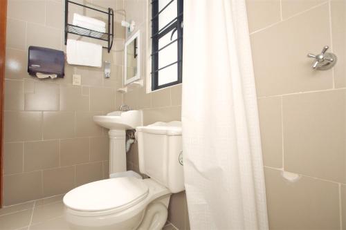 a bathroom with a white toilet and a sink at Casa Amaiur in Huichapan