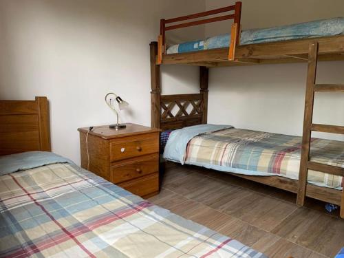 1 dormitorio con 2 literas y escritorio con lámpara en La Gemelita en Capilla del Monte