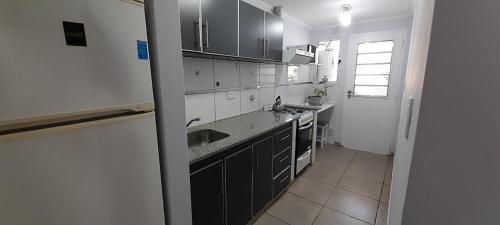 une cuisine avec des armoires noires et blanches et un évier dans l'établissement Departamento MICHE, à Tandil