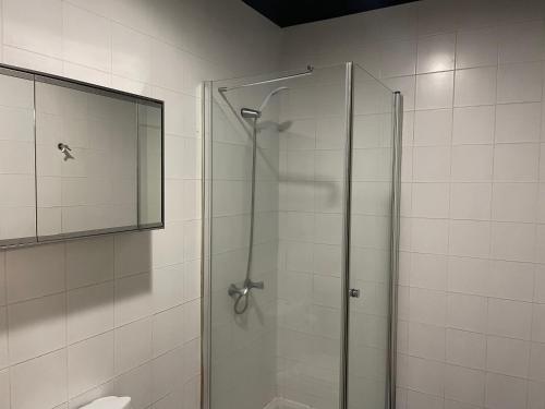 La salle de bains est pourvue d'une douche avec une porte en verre. dans l'établissement Sea Breeze Studios, à Porto da Cruz