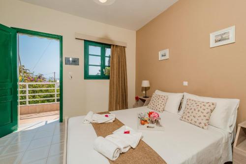 a living room with a white bed and a balcony at Alpha Stegna Sun in Archangelos