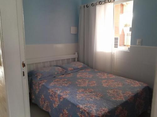 Un dormitorio pequeño con una cama y una ventana. en Casa Completa no Rosa, en Praia do Rosa