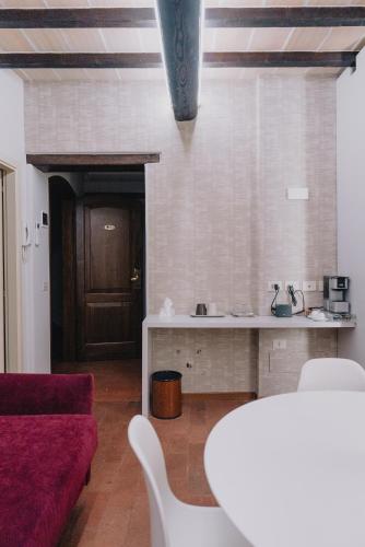 a living room with a table and a red couch at Locanda Del Feudo Suite & Restaurant in Castelvetro di Modena