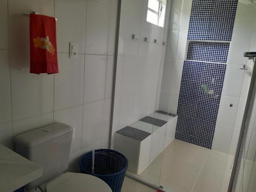 a white bathroom with a shower and a toilet at Casa Completa no Rosa in Praia do Rosa