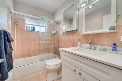 La salle de bains est pourvue de toilettes, d'une baignoire et d'un lavabo. dans l'établissement Modern home 10 minutes from Fort Lauderdale beach!, à Fort Lauderdale