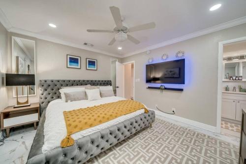 a bedroom with a large bed and a ceiling fan at Modern home 10 minutes from Fort Lauderdale beach! in Fort Lauderdale