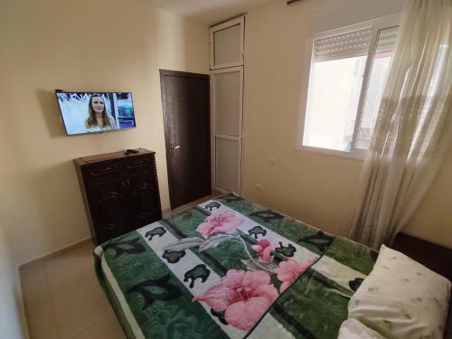 - une chambre avec un lit orné de fleurs roses dans l'établissement Appartement ifrane, à Ifrane