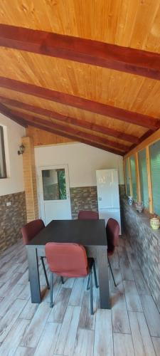 a table and chairs in a room with a wooden ceiling at Casa Happy Family Bran in Bran