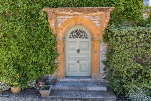 a blue door with an archway in a building at The Mount Somerton Retreat - Nr Bruton, Glastonbury, The spectacular Wells Cathedral, Millfield School, Leonardo Helicopters, Yeovilton in Somerton