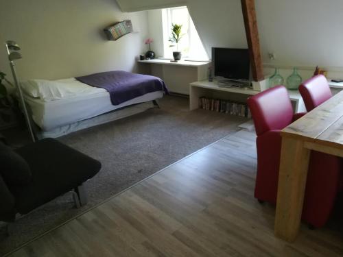 um quarto com uma cama, uma mesa e cadeiras em B&B De Goffert em Nijmegen