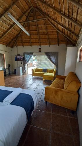 a bedroom with a bed and a living room at 28 at Van Den Bos International Guesthouse in Edenvale