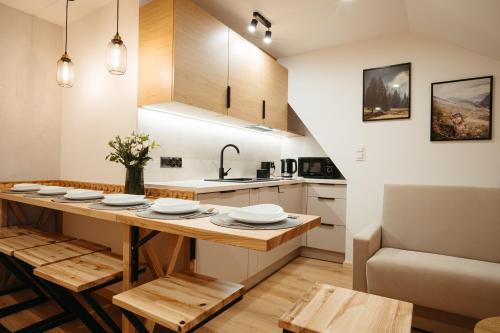a kitchen with a wooden table and a counter top at Novopolka Apartamenty in Rzepiska