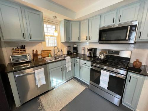 a kitchen with white cabinets and stainless steel appliances at New! Cozy 4-bedroom w/ free parking. Dogs welcome! in Berea