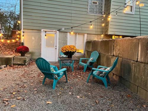 three green chairs and a table in front of a house at New! Cozy 4-bedroom w/ free parking. Dogs welcome! in Berea