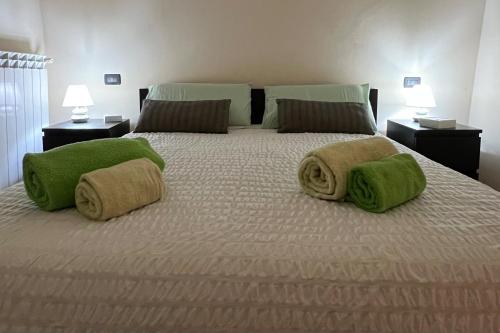 a bedroom with a bed with green towels on it at Saint Michel Apartment in Dolceacqua