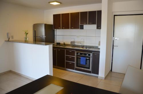 una cucina con frigorifero e piano cottura forno superiore di Departamento Entero con Pileta Calasanzs a Córdoba