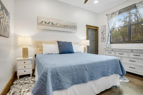 a bedroom with a blue bed and a window at West Side Nest in Fredericksburg