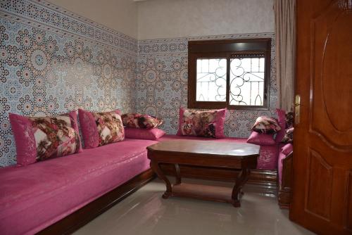 un soggiorno con divano rosa e finestra di Ozoud high standing appartment a Ouzoud