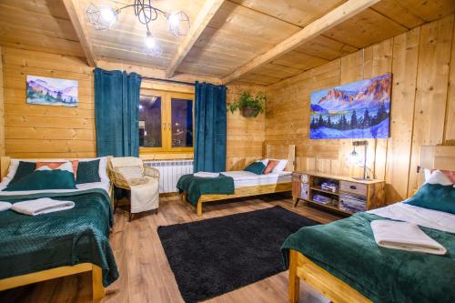 um quarto com 2 camas num quarto com paredes de madeira em Apartament Stryszek Alpinistyczny em Bukowina Tatrzańska
