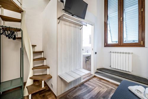 a small room with a staircase and a tv at B&B Lorenzo de' Medici in Florence