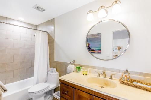 ein Badezimmer mit einem Waschbecken, einem WC und einem Spiegel in der Unterkunft Plaza Del Sol in Islamorada