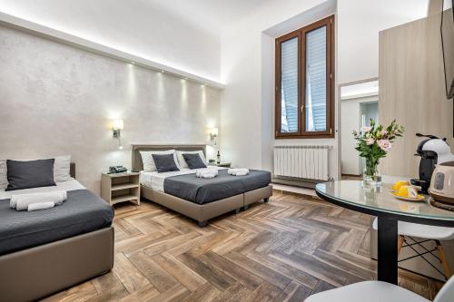 a bedroom with two beds and a table at B&B Lorenzo de' Medici in Florence