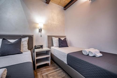 two beds in a small room with towels on them at B&B Lorenzo de' Medici in Florence