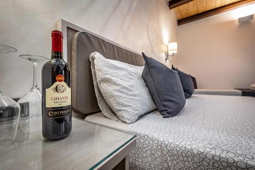 a bottle of wine sitting on a table next to a bed at B&B Lorenzo de' Medici in Florence