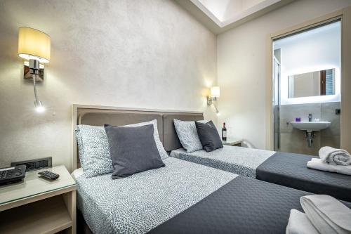 a hotel room with two beds and a sink at B&B Lorenzo de' Medici in Florence