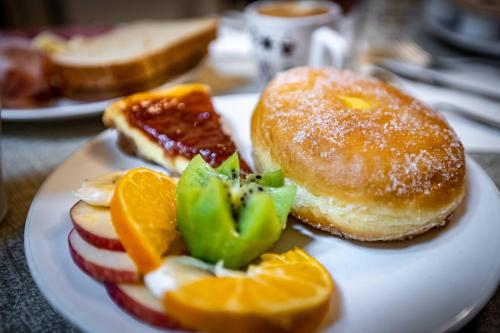 a plate of food with donuts and fruit on it at B&B Lorenzo de' Medici in Florence