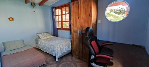 a bedroom with a bed and a chair and a window at Casa Jardín de Hadas con Vista Panorámica in Pisco Elqui