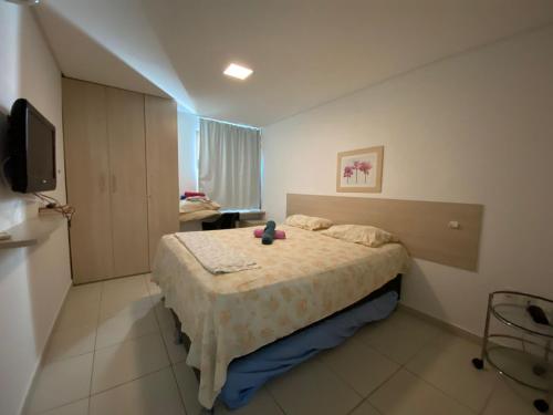 1 dormitorio con 1 cama y TV. en Apartamento Carneiros Beach Resort en Tamandaré