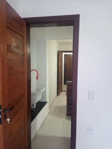 a bathroom with a sink and a wooden door at Casas Bérgamo in Morro de São Paulo