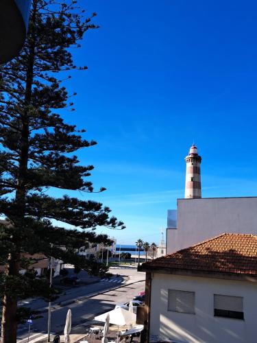 a lighthouse sitting on top of a white building at Apartamento Mar e Sol in Gafanha da Nazaré