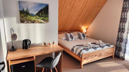 a small bedroom with a bed and a desk at Willa Adamówka in Zakopane