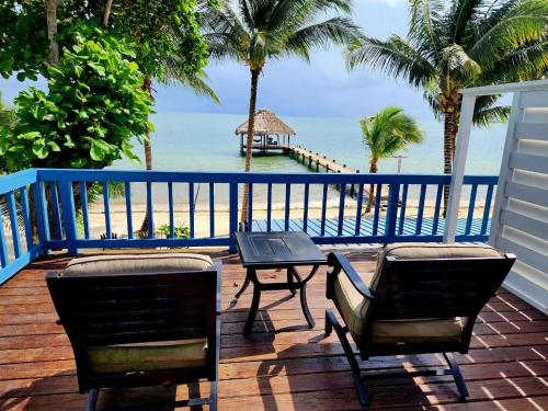 uma varanda com uma mesa e cadeiras e o oceano em Maya Beach Hotel em Maya Beach