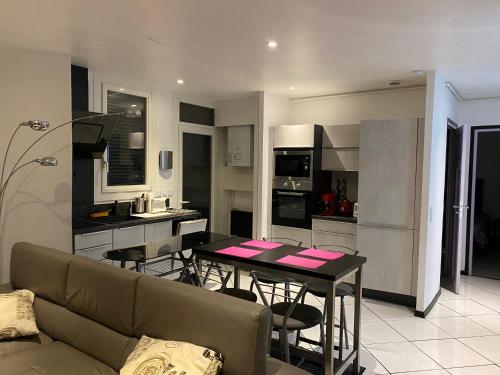 salon i kuchnia z kanapą i stołem w obiekcie VILLA LUXUEUSE w mieście Tarbes