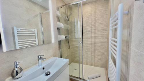 y baño con lavabo y ducha acristalada. en « LA SUITE »Superbe appartement NEUF, Front de mer, en Menton