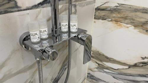 a shower with four bottles on a stand in a bathroom at D&D Schönbrunner Deluxe Apartment in Vienna
