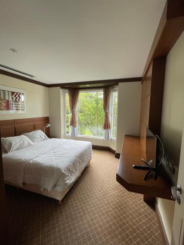 a bedroom with a bed and a large window at Privilege Apart hotel Mountain Village in Canela