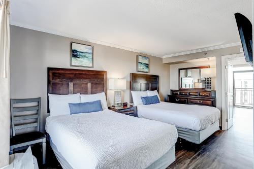 ein Hotelzimmer mit 2 Betten und einem Stuhl in der Unterkunft Caravelle Resort Unit 1502 in Myrtle Beach