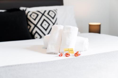 ein weißes Bett mit weißen Handtüchern und Beeren darauf in der Unterkunft Vibrant 1 Bedroom Cosy Apartment - City Centre in Birmingham