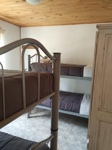 a room with two bunk beds and a wooden ceiling at Cabañas El Labriego in Malargüe