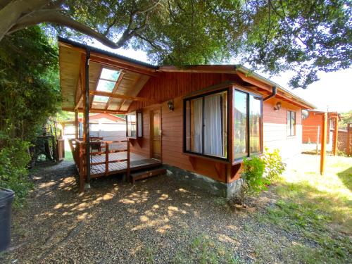 a small wooden house with a porch and windows at Cabañas gonzalez caniupan in Licán Ray