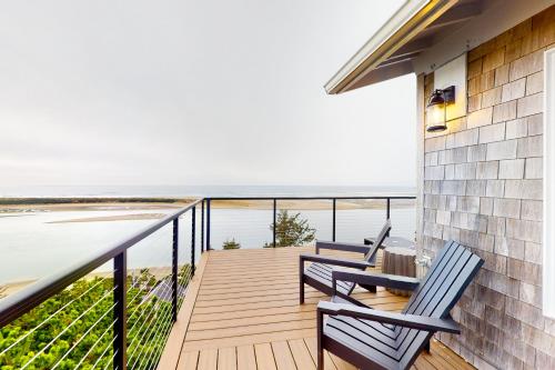 a balcony with two chairs and a table and the ocean at The Crew House in Tillamook