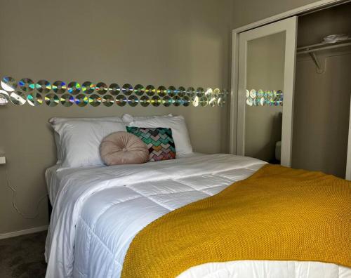 a bedroom with a white bed with a yellow blanket at Luxury Condo 2 bed 2 bath near Downtown KC in Kansas City