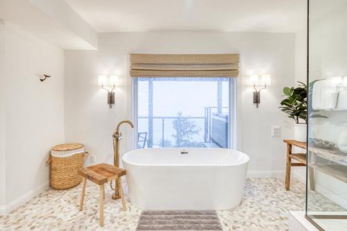 a white bath tub in a bathroom with a window at The Crew House in Tillamook