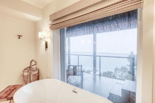 a bath tub in a bathroom with a large window at The Crew House in Tillamook