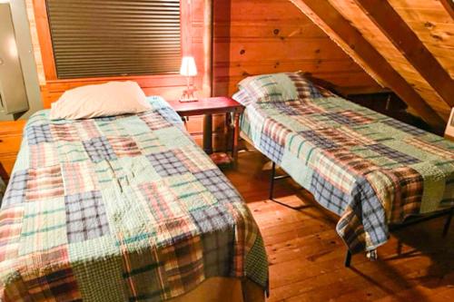 two twin beds in a room with a table at Serenity on Trickey Cove in Naples