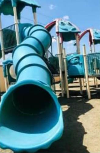 a playground with a blue slide at a park at Milimani Furnished Apartments in Nakuru
